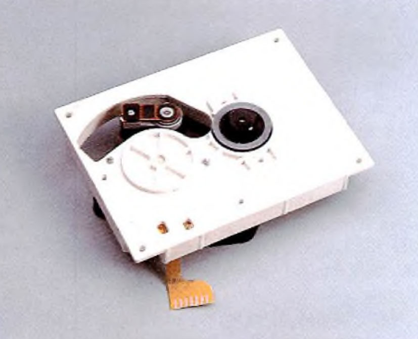 The new CD mechanism (CDM2) comprising pick-up, swing arm and disc drive motor. Just 30 mm high and with an operating temperature range of —30 to +75 °C, the mechanism is suitable for home, car and portable players. The size reduction has been achieved, without the need to resort to folded optics, by using a new optical arrangement that requires only four components